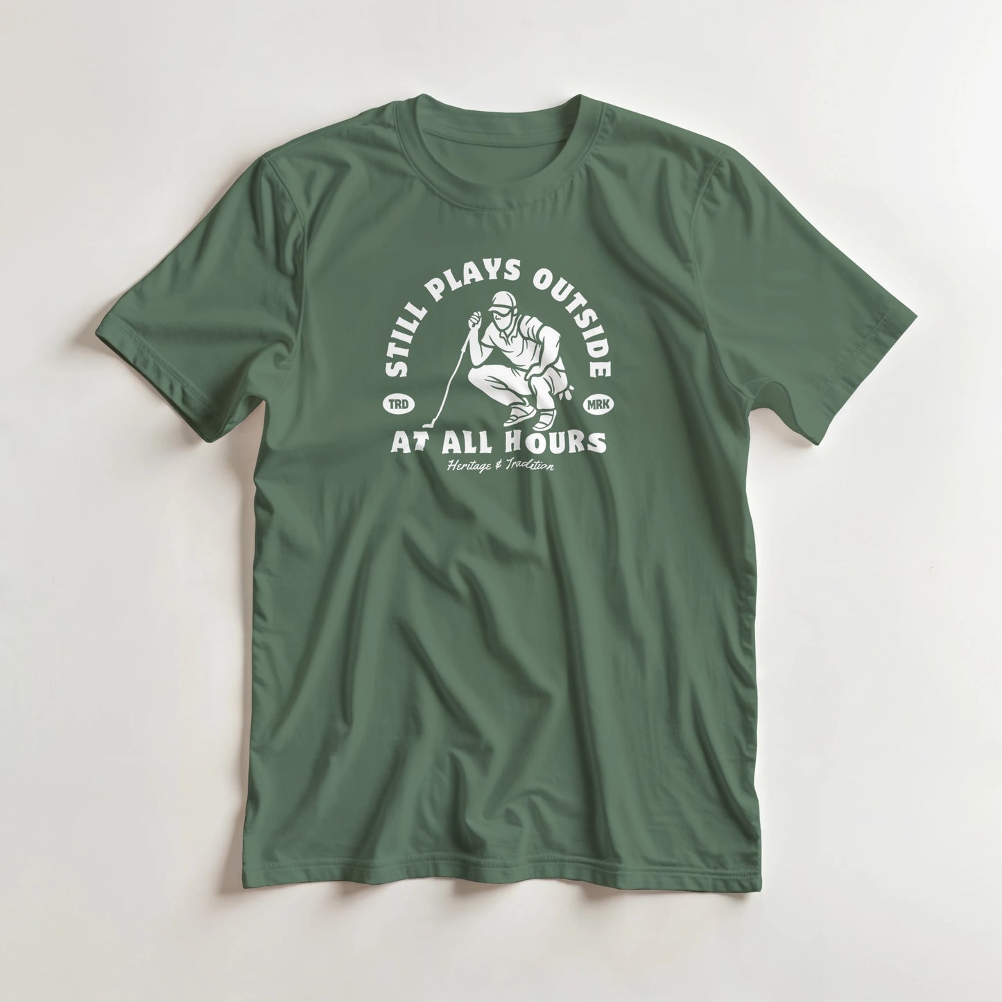At All Hours T-Shirt in Military Green lying on a plain floor. T-shirt is a unisex cut and 100 per cent cotton.