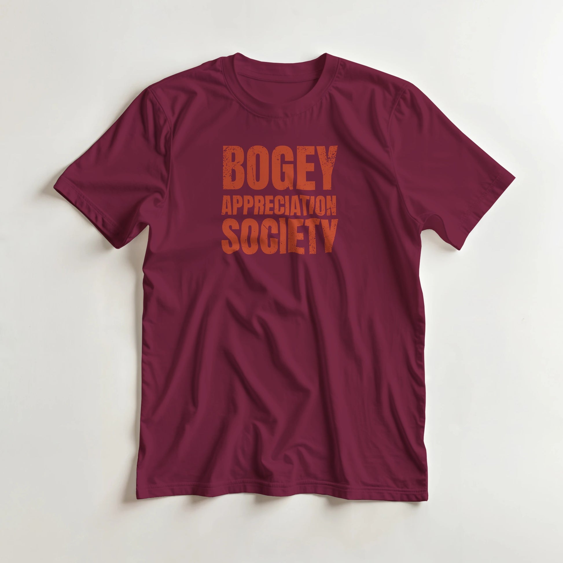 Bogey Appreciation T-Shirt in Maroon S lying on a plain floor. T-shirt is a unisex cut and 100 per cent cotton.