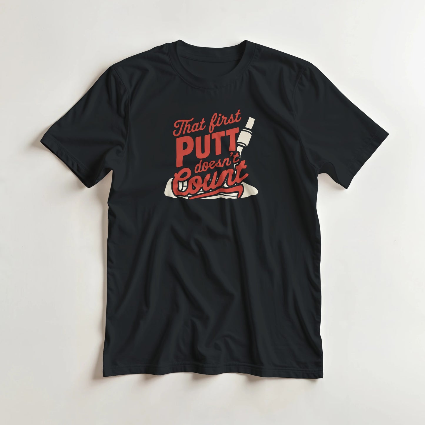 First Putt T-Shirt in Black lying on a plain floor. T-shirt is a unisex cut and 100 per cent cotton.