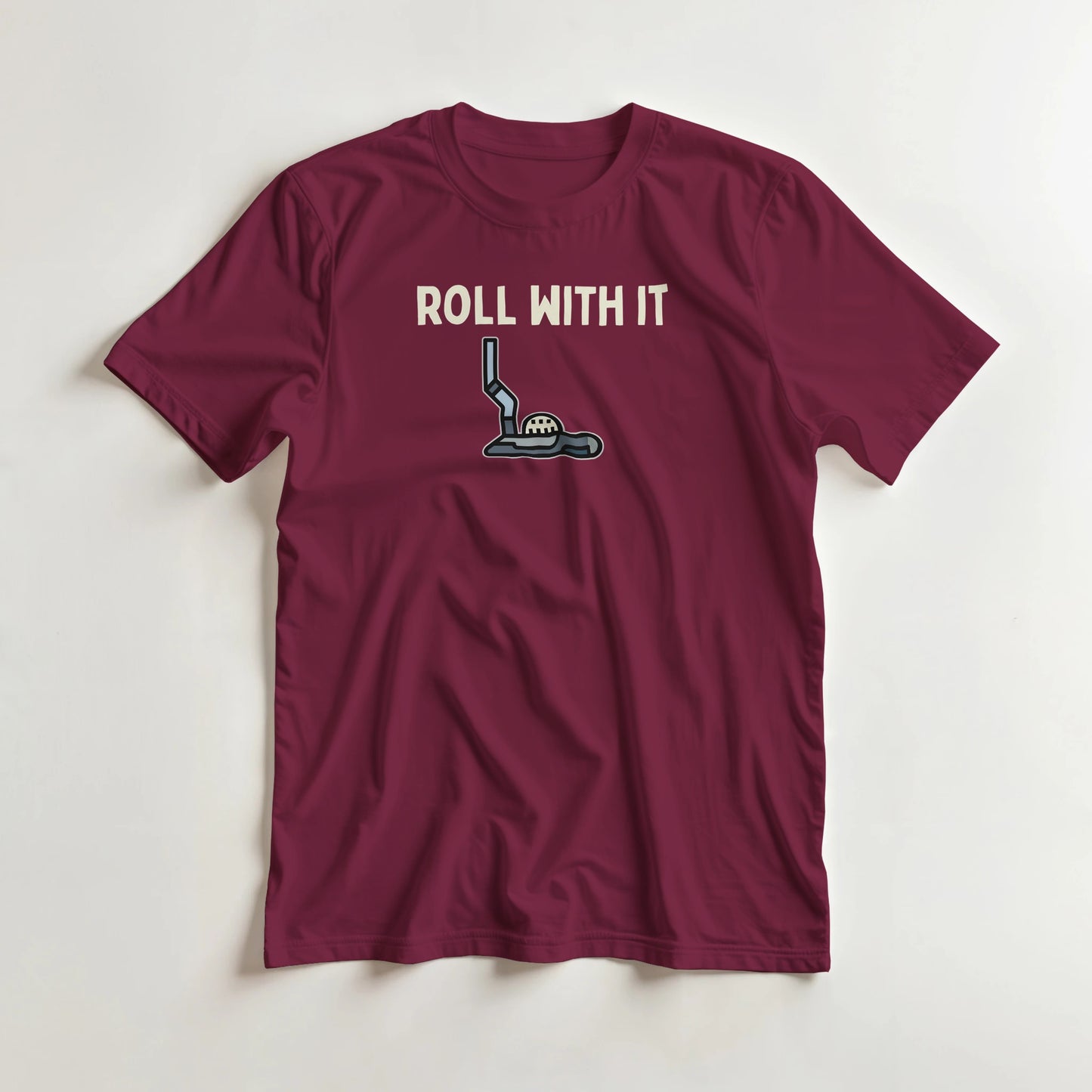 Roll With It T-Shirt in Maroon lying on a plain floor. T-shirt is a unisex cut and 100 per cent cotton.