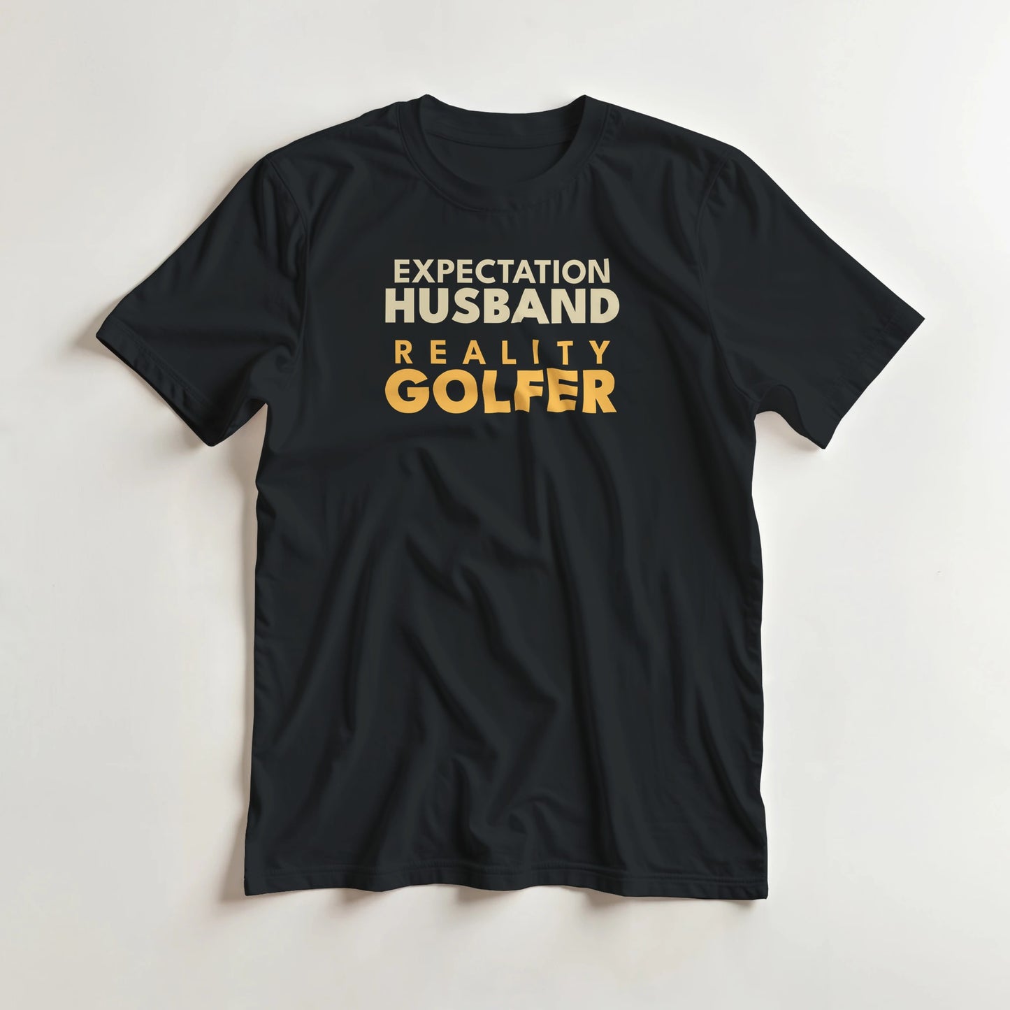 Reality Golfer T-Shirt in Black M lying on a plain floor. T-shirt is a unisex cut and 100 per cent cotton.
