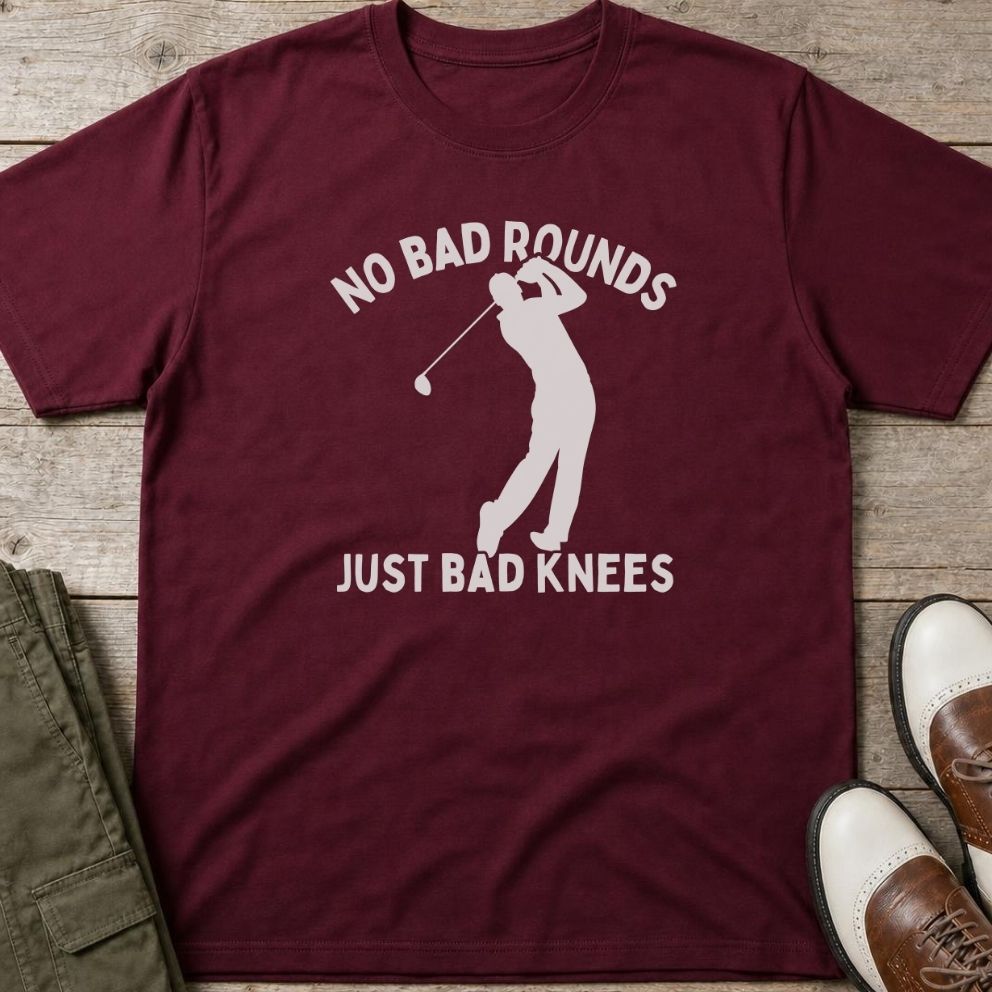 Bad Knees T-Shirt in Maroon lying on a plain floor. T-shirt is a unisex cut and 100 per cent cotton.