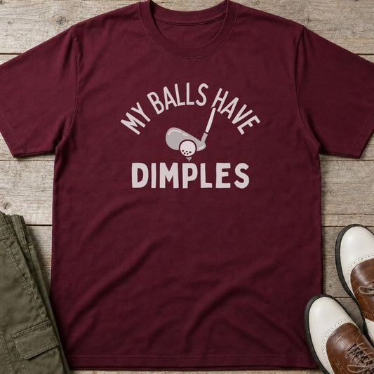Dimples T-Shirt in Maroon lying on a plain floor. T-shirt is a unisex cut and 100 per cent cotton.
