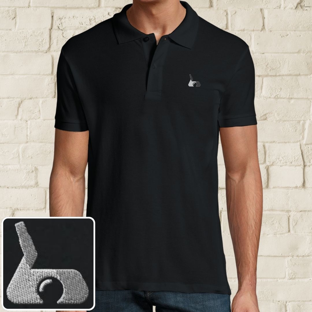 Putter Polo in Black on a light wooden floor lying next to headphones and golf shoes.