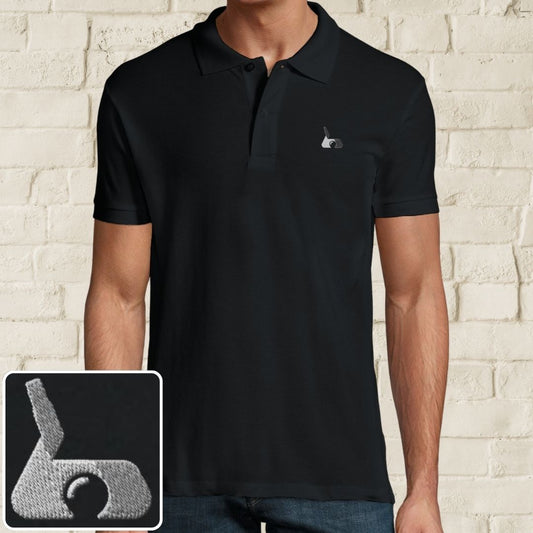 Putter Polo in Black on a light wooden floor lying next to headphones and golf shoes.