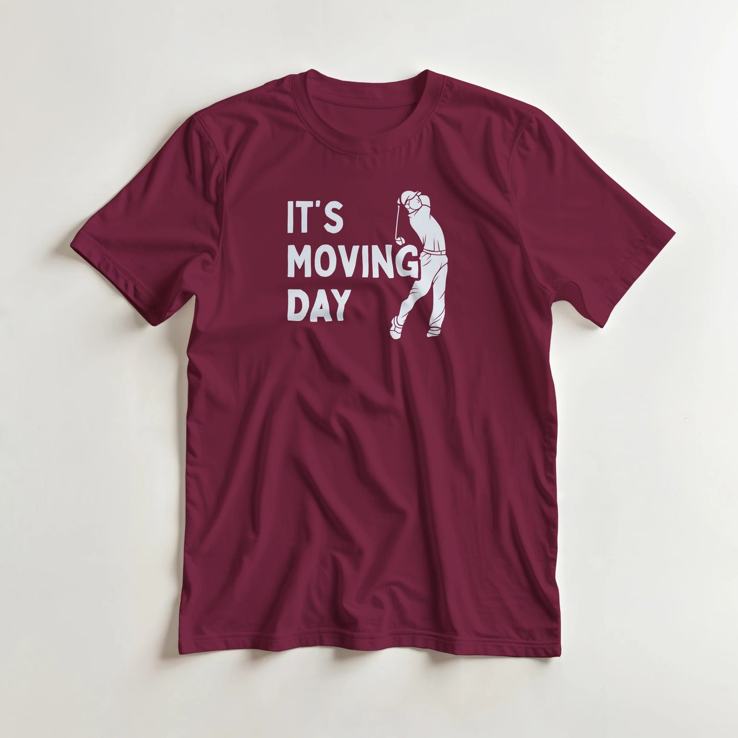 Moving Day T-Shirt in Maroon L lying on a plain floor. T-shirt is a unisex cut and 100 per cent cotton.