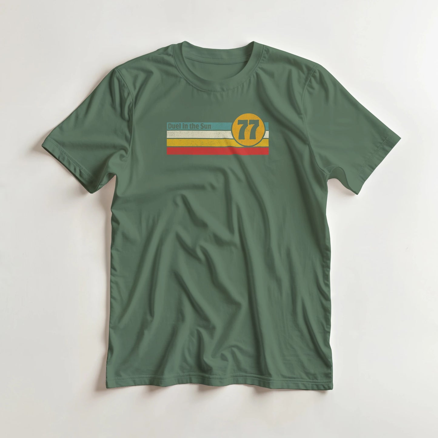 Duel Sun T-Shirt in Military Green L lying on a plain floor. T-shirt is a unisex cut and 100 per cent cotton.