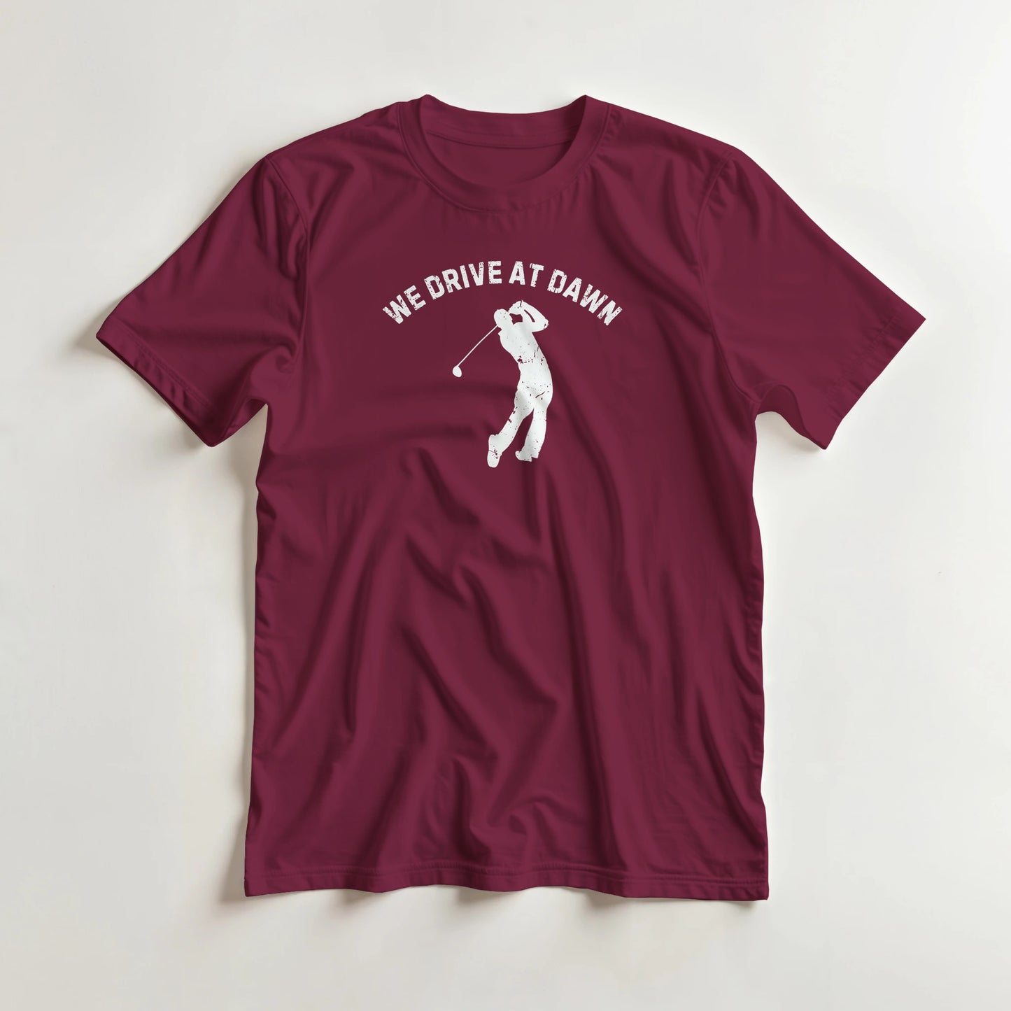 We Drive T-Shirt in Maroon XL lying on a plain floor. T-shirt is a unisex cut and 100 per cent cotton.