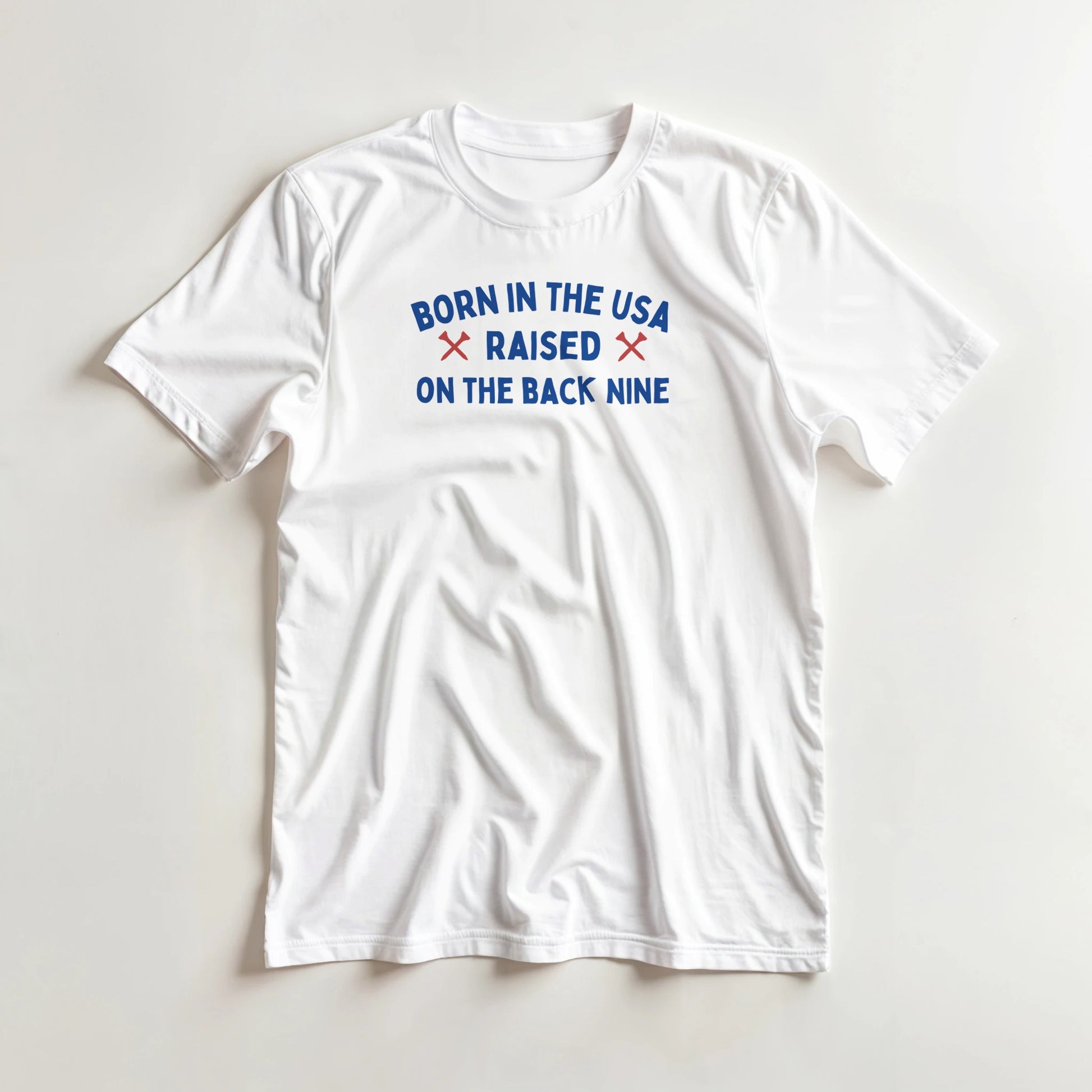 Born In The USA T-Shirt in lying on a plain floor. T-shirt is a unisex cut and 100 per cent cotton.