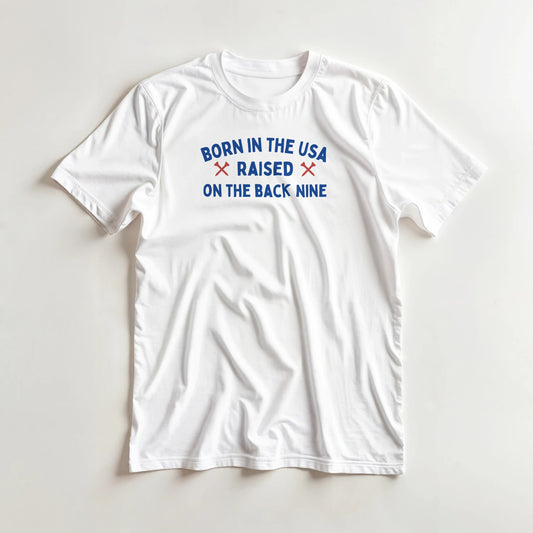 Born In The USA T-Shirt in lying on a plain floor. T-shirt is a unisex cut and 100 per cent cotton.