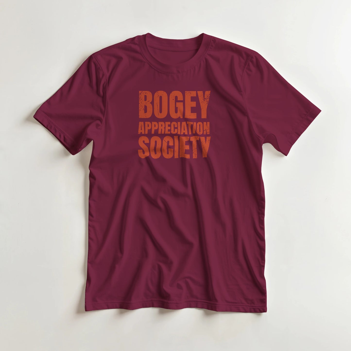 Bogey Appreciation T-Shirt in Maroon L lying on a plain floor. T-shirt is a unisex cut and 100 per cent cotton.