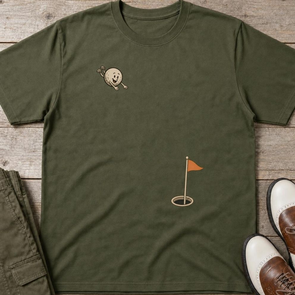 Flying Golf Ball T-Shirt in Military Green lying on a plain floor. T-shirt is a unisex cut and 100 per cent cotton.
