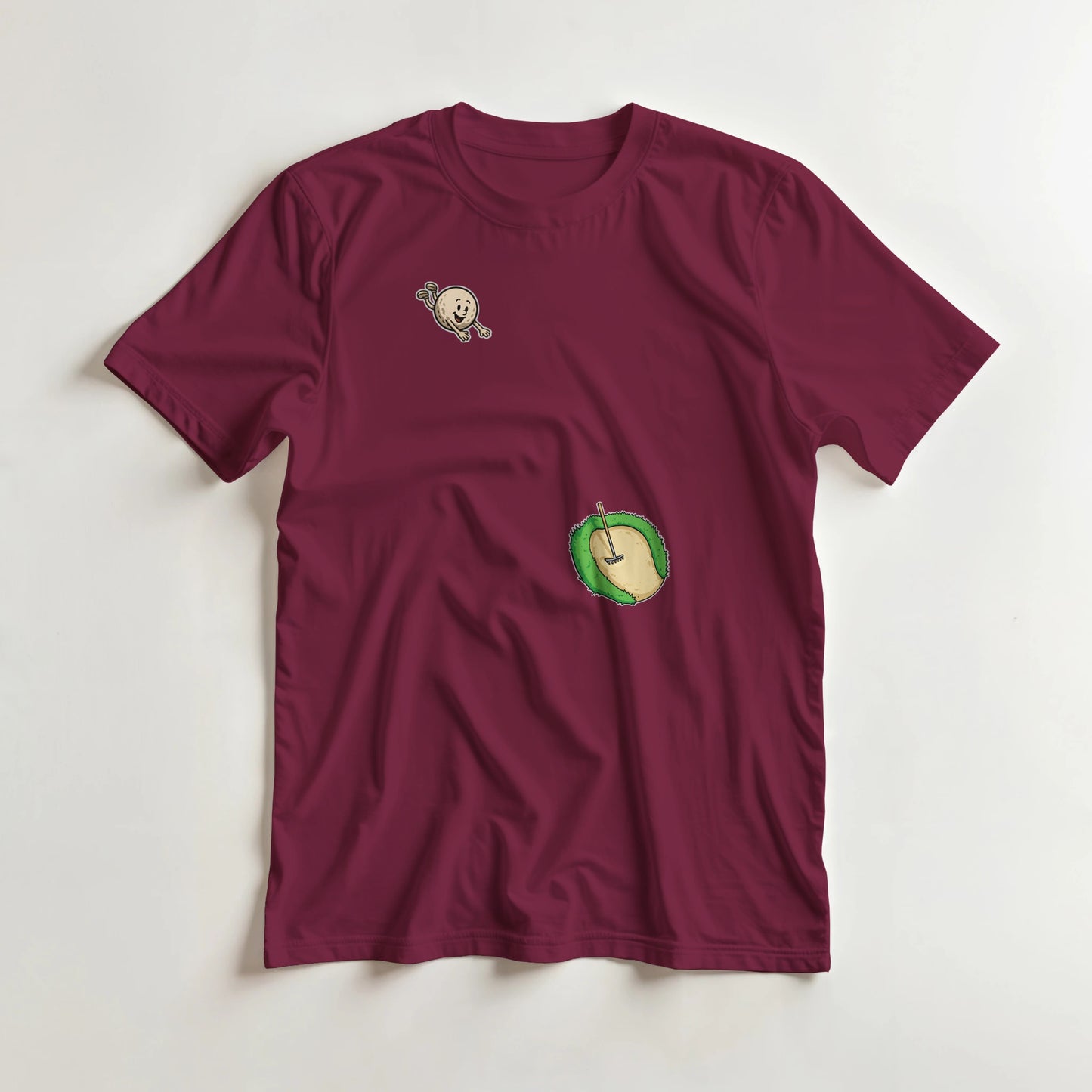 Flying Sand Trap T-Shirt in Maroon lying on a plain floor. T-shirt is a unisex cut and 100 per cent cotton.