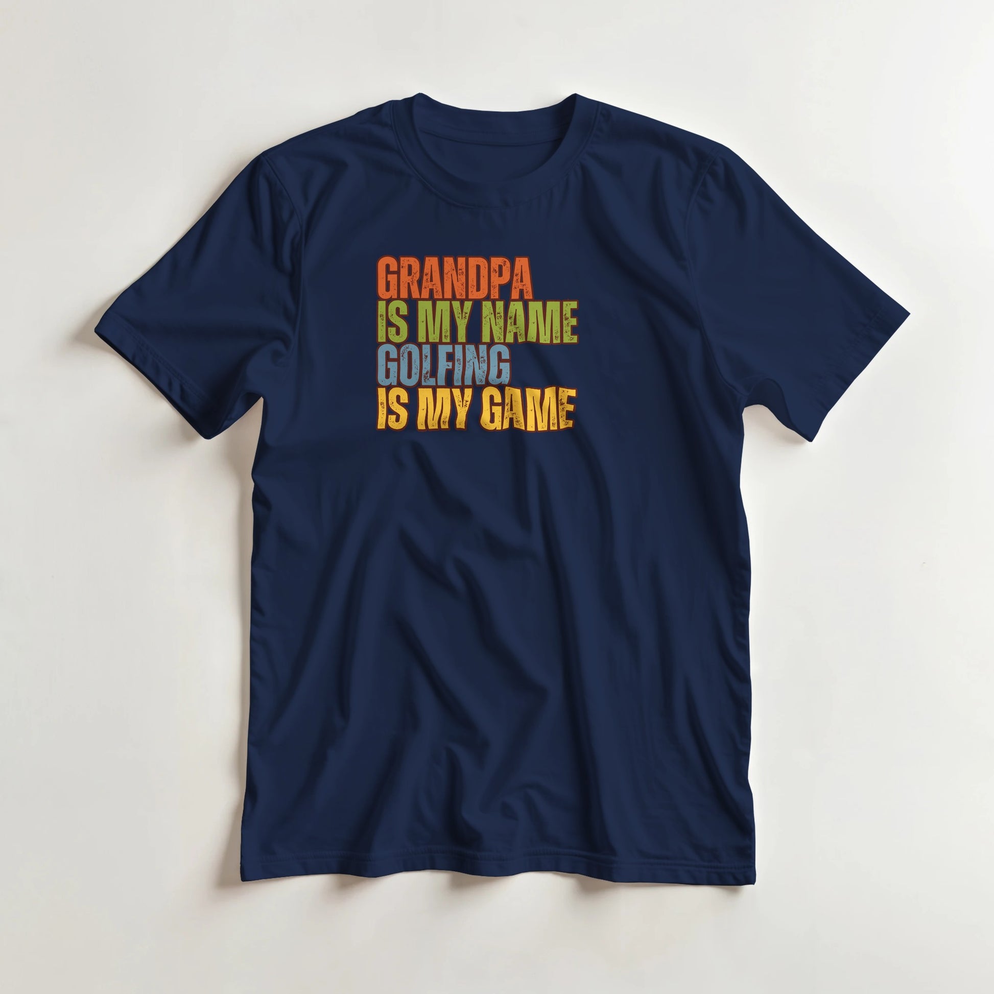 Grandpa Golfing T-Shirt in Navy lying on a plain floor. T-shirt is a unisex cut and 100 per cent cotton.