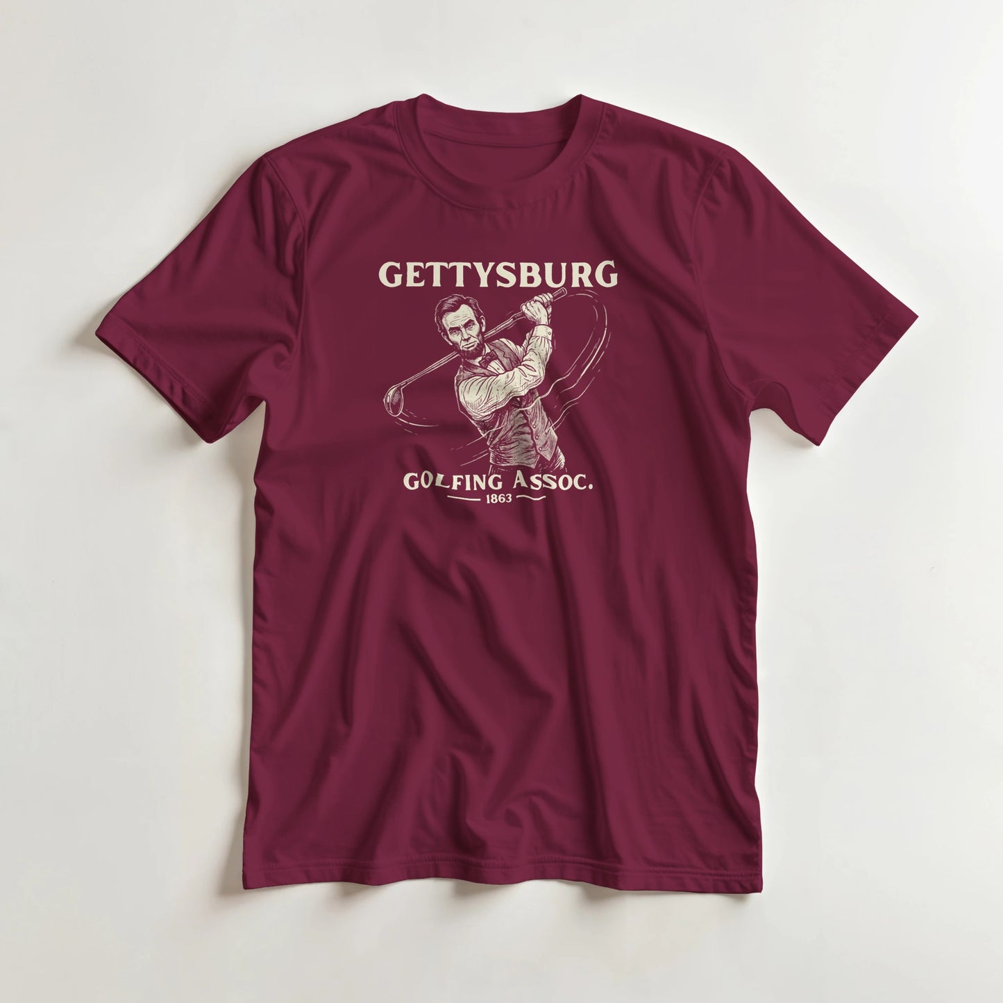 Gettysburg T-Shirt in Maroon lying on a plain floor. T-shirt is a unisex cut and 100 per cent cotton.