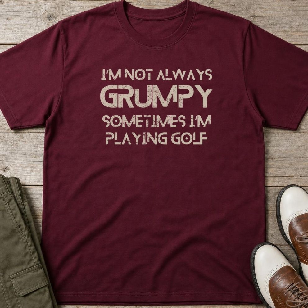 Grumpy Golf T-Shirt in Maroon lying on a plain floor. T-shirt is a unisex cut and 100 per cent cotton.