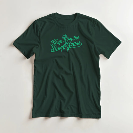 Short Grass T-Shirt in Forest Green lying on a plain floor. T-shirt is a unisex cut and 100 per cent cotton.