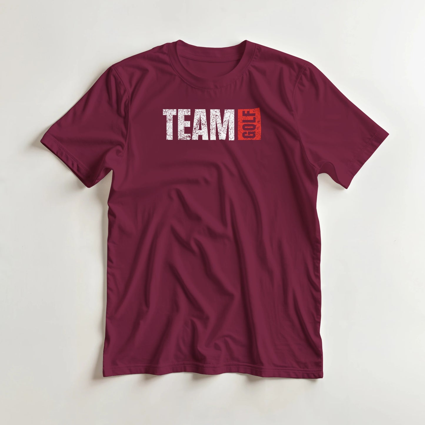 Team Golf T-Shirt in Maroon lying on a plain floor. T-shirt is a unisex cut and 100 per cent cotton.