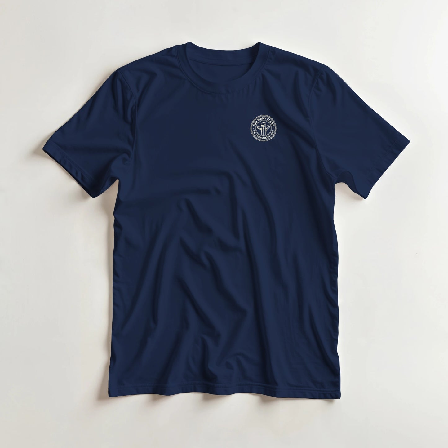 Too Many Clubs Pocket T-Shirt in Navy lying on a plain floor. T-shirt is a unisex cut and 100 per cent cotton.