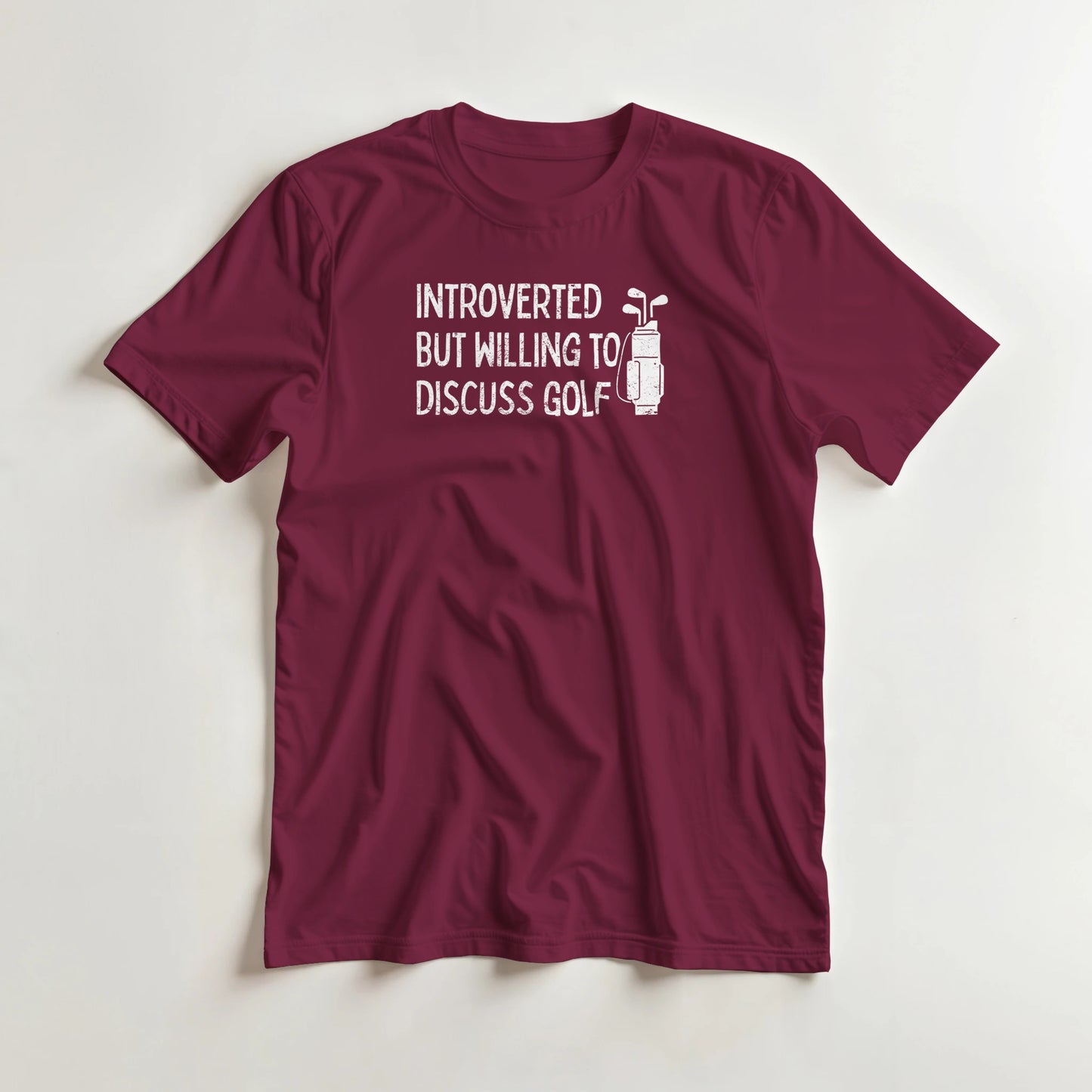 Introverted T-Shirt in Maroon lying on a plain floor. T-shirt is a unisex cut and 100 per cent cotton.
