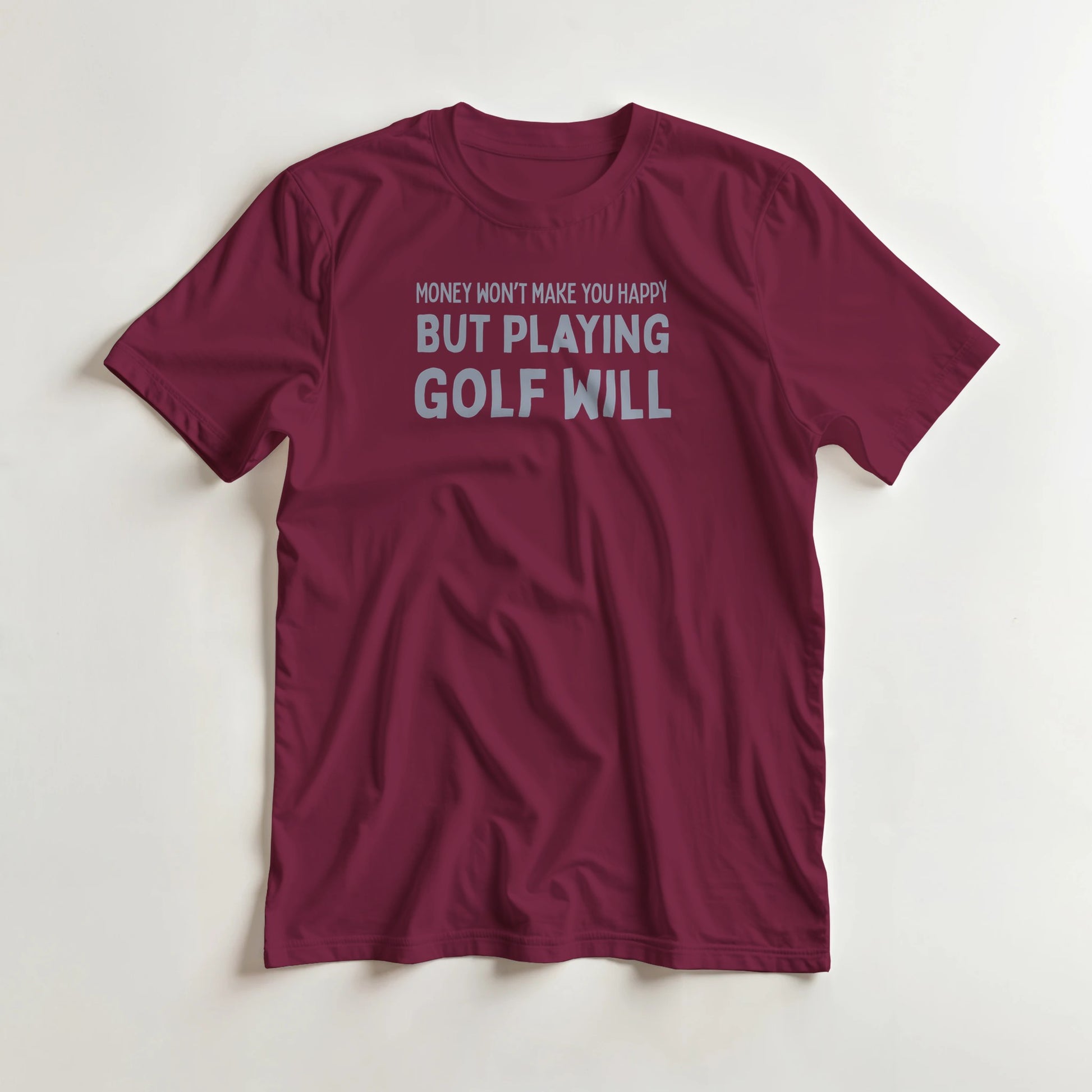 Playing Golf T-Shirt in Maroon lying on a plain floor. T-shirt is a unisex cut and 100 per cent cotton.