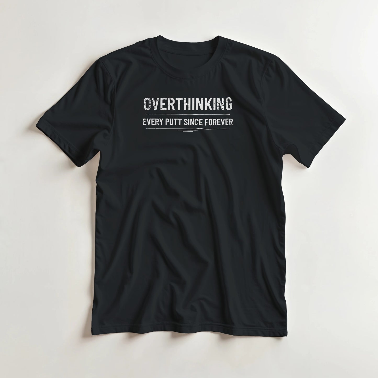 Every Putt T-Shirt in Black lying on a plain floor. T-shirt is a unisex cut and 100 per cent cotton.