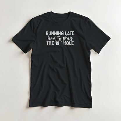 Running Late T-Shirt in Black lying on a plain floor. T-shirt is a unisex cut and 100 per cent cotton.