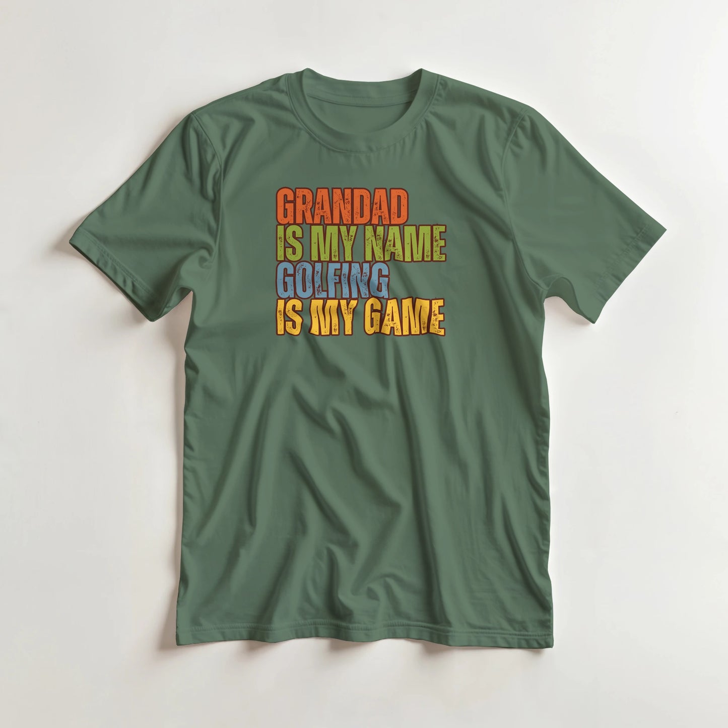 Grandad Golfing T-Shirt in Military Green L lying on a plain floor. T-shirt is a unisex cut and 100 per cent cotton.