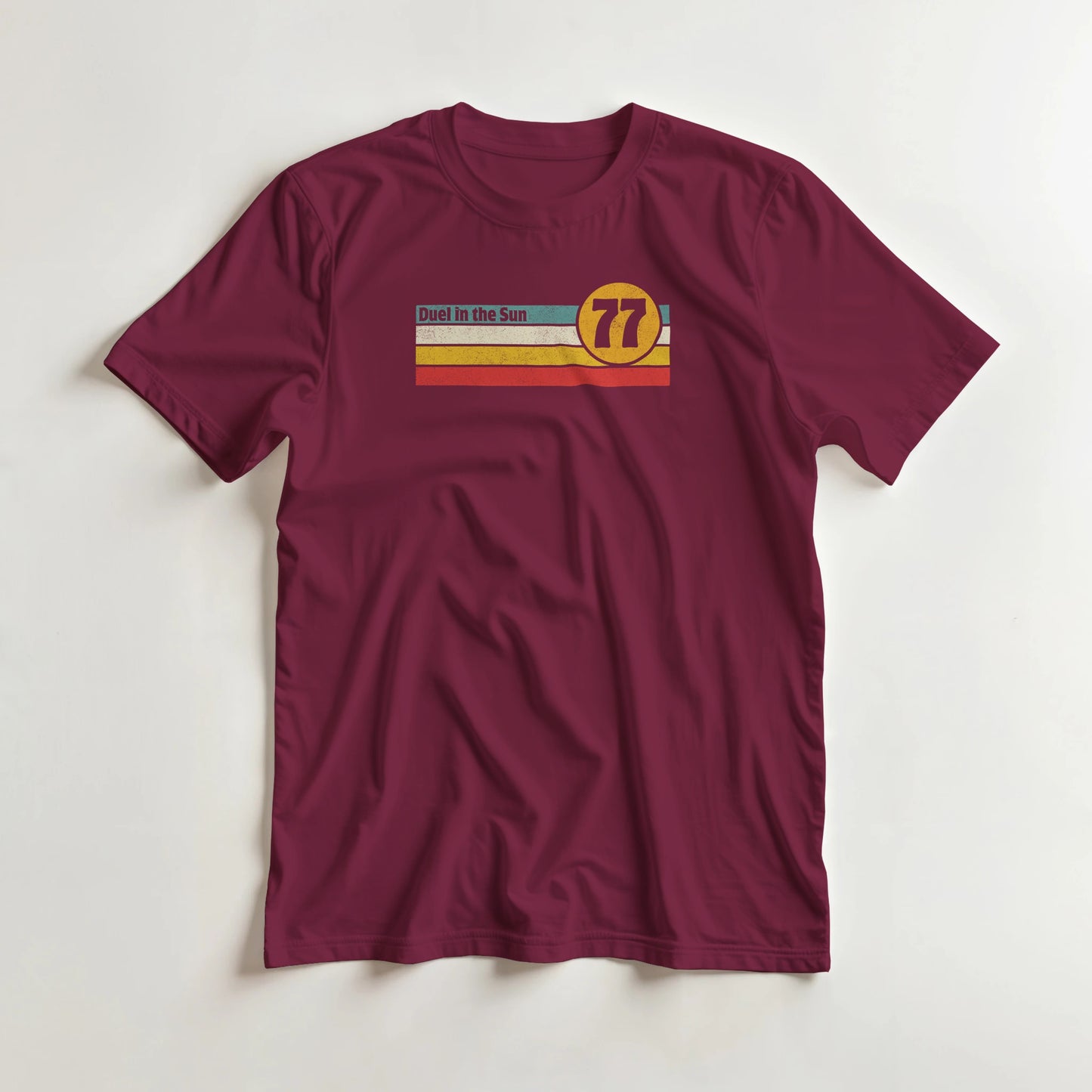 Duel Sun T-Shirt in Maroon S lying on a plain floor. T-shirt is a unisex cut and 100 per cent cotton.