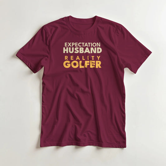 Reality Golfer T-Shirt in Maroon S lying on a plain floor. T-shirt is a unisex cut and 100 per cent cotton.