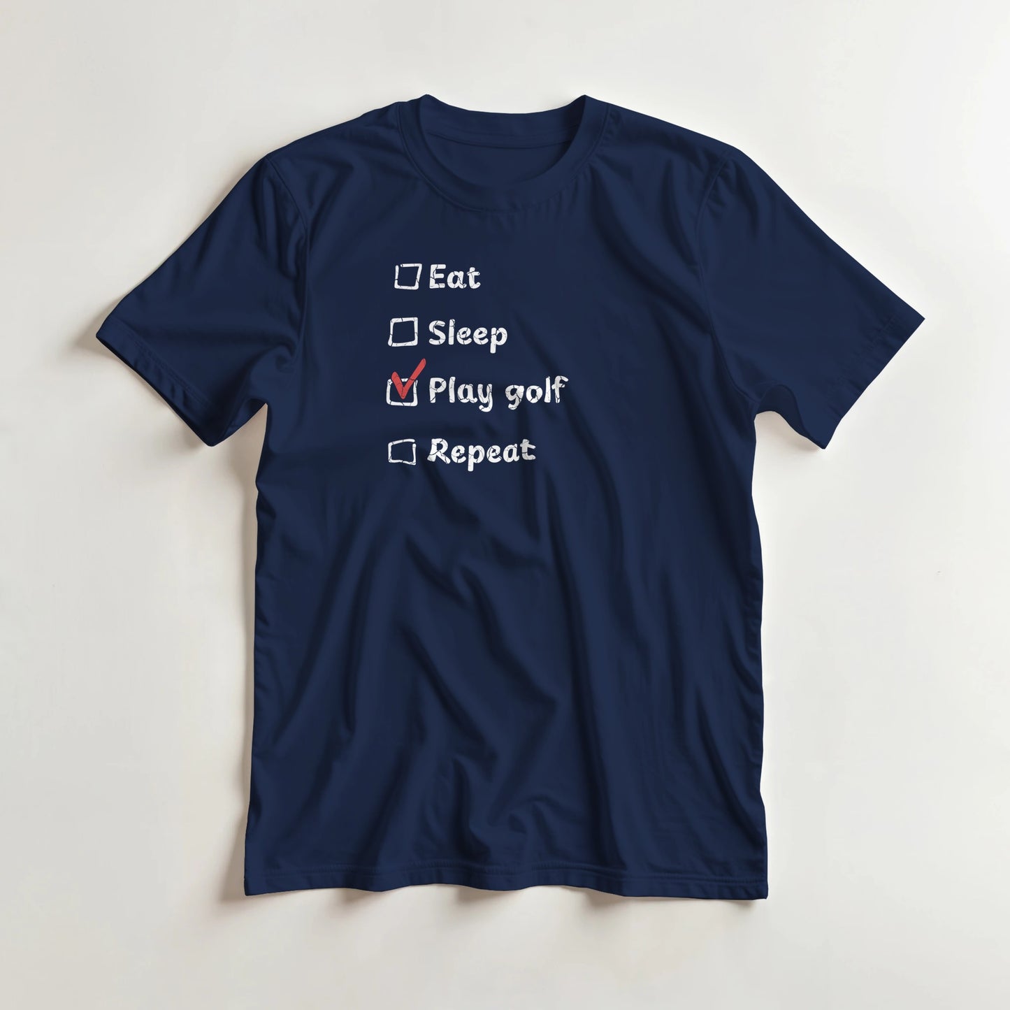 Golf Repeat T-Shirt in Navy lying on a plain floor. T-shirt is a unisex cut and 100 per cent cotton.