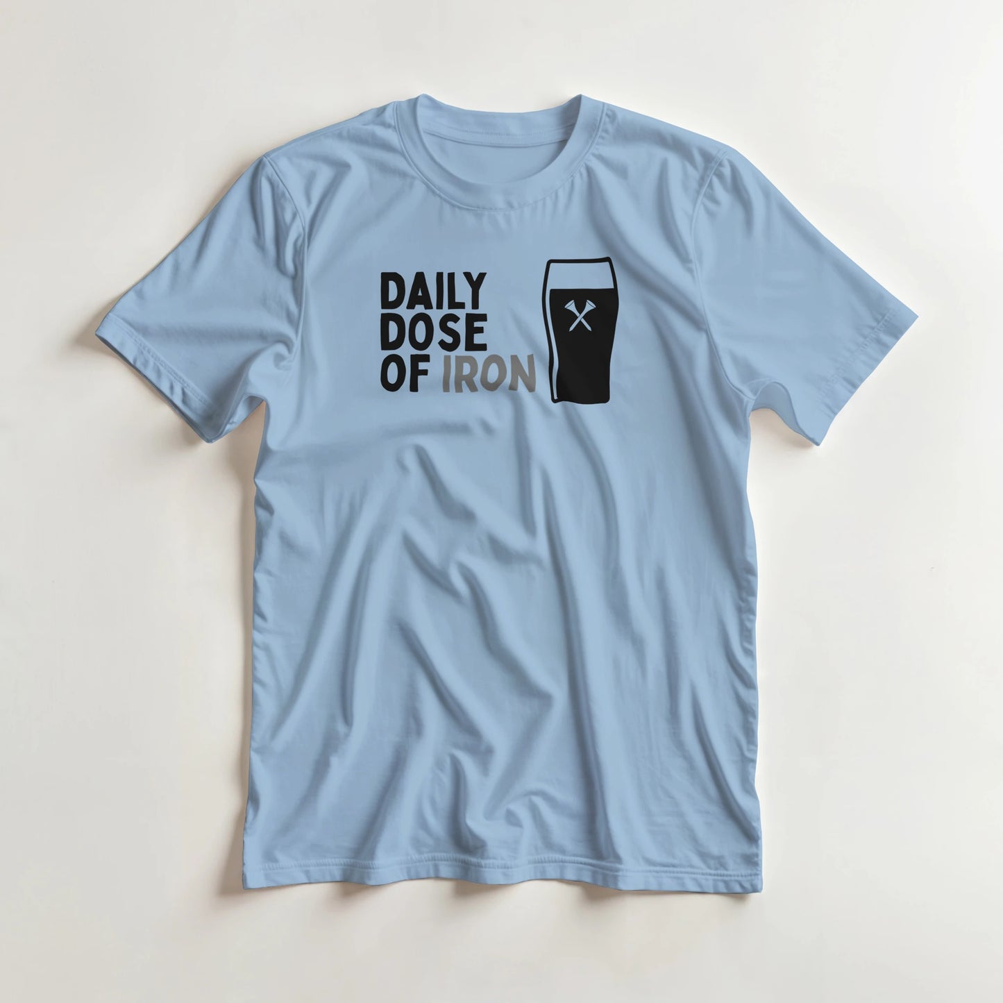 Dose Of Iron T-Shirt in Light Blue lying on a plain floor. T-shirt is a unisex cut and 100 per cent cotton.