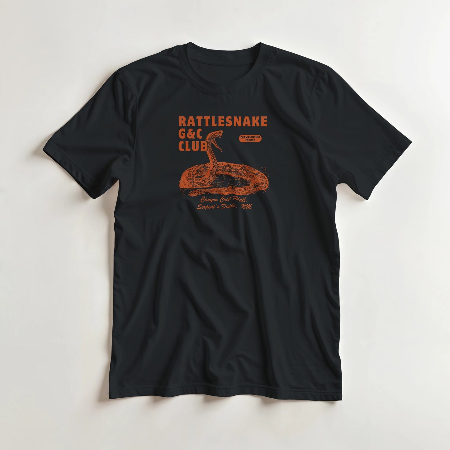 Rattlesnake G&C T-Shirt in Black M lying on a plain floor. T-shirt is a unisex cut and 100 per cent cotton.