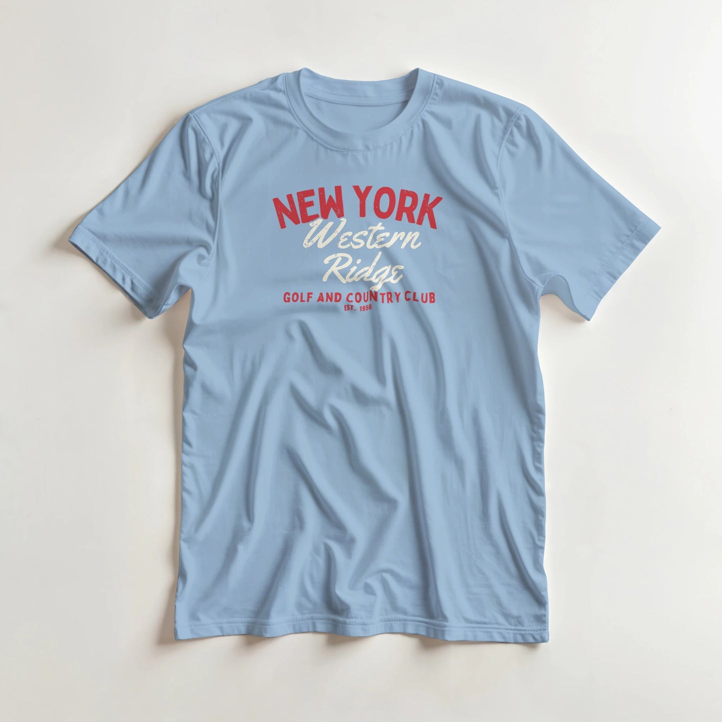 Western Ridge T-Shirt in Light Blue lying on a plain floor. T-shirt is a unisex cut and 100 per cent cotton.