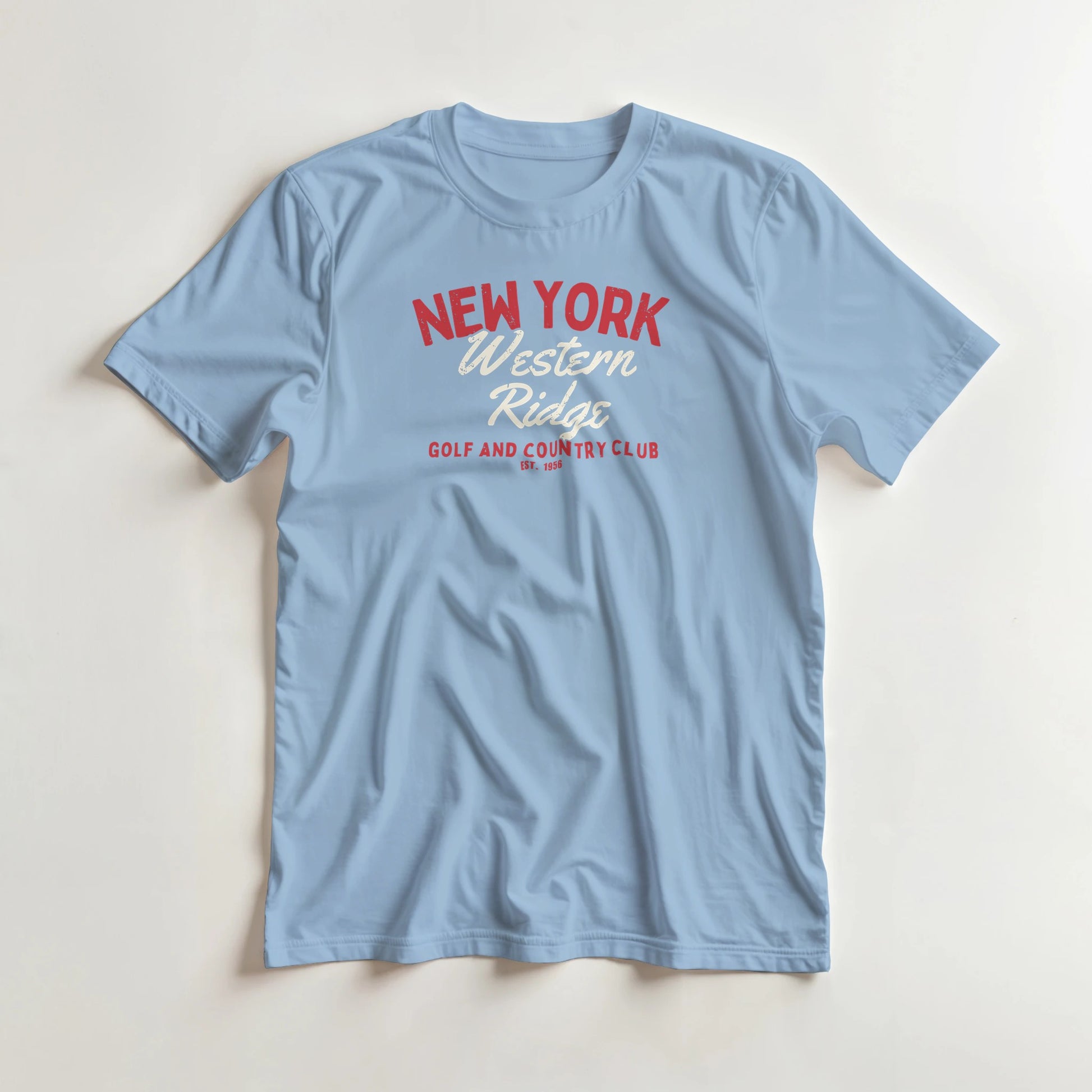 Western Ridge T-Shirt in Light Blue lying on a plain floor. T-shirt is a unisex cut and 100 per cent cotton.
