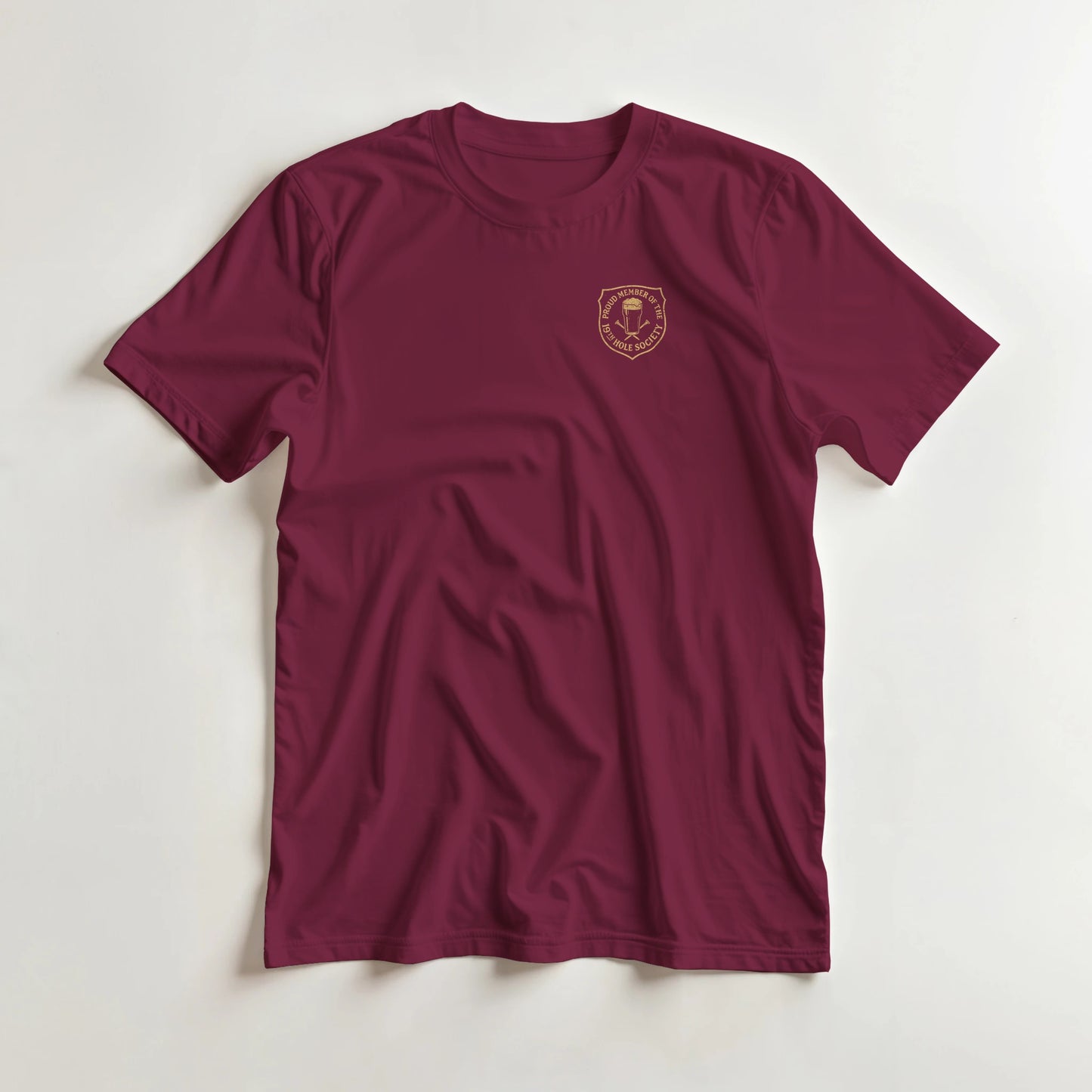 19th Hole T-Shirt in Maroon S lying on a plain floor. T-shirt is a unisex cut and 100 per cent cotton.