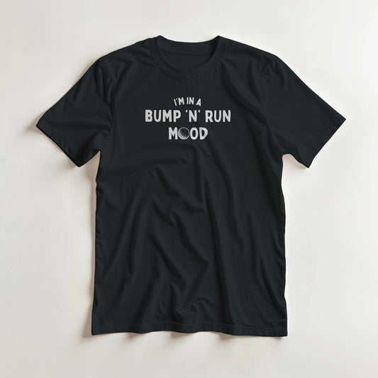 Bump 'N' Run T-Shirt in Black lying on a plain floor. T-shirt is a unisex cut and 100 per cent cotton.