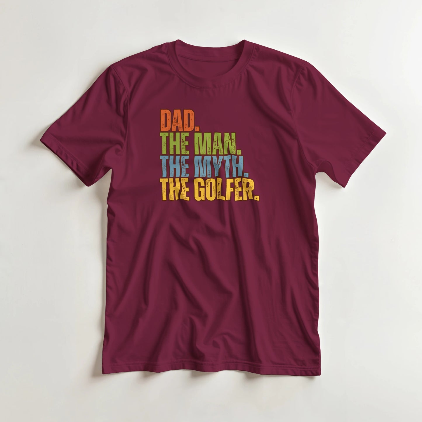 Dad The Legend Golfer T-Shirt in Maroon XL lying on a plain floor. T-shirt is a unisex cut and 100 per cent cotton.