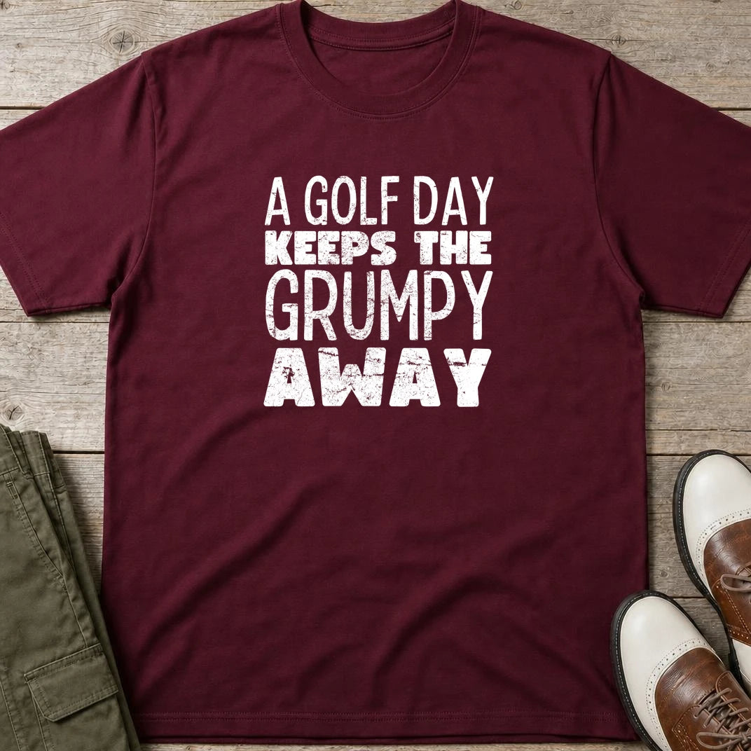 A Golf Day T-Shirt in Maroon lying on a plain floor. T-shirt is a unisex cut and 100 per cent cotton.