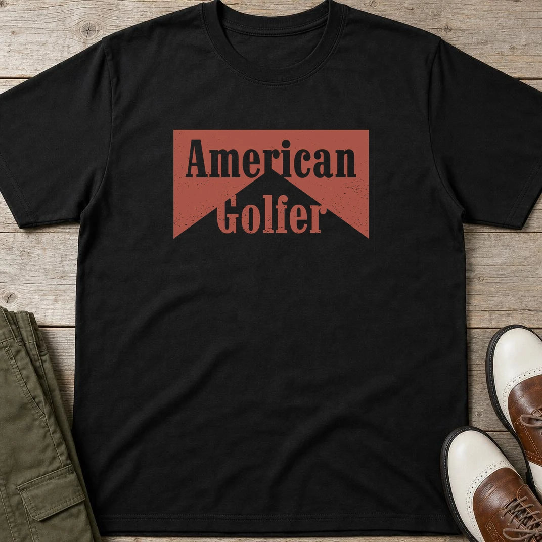 American Golfer T-Shirt in Black lying on a plain floor. T-shirt is a unisex cut and 100 per cent cotton.