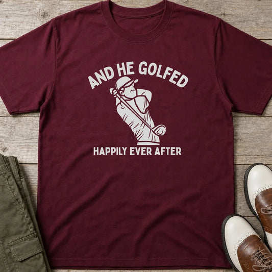 And He Golfed T-Shirt in Maroon lying on a plain floor. T-shirt is a unisex cut and 100 per cent cotton.