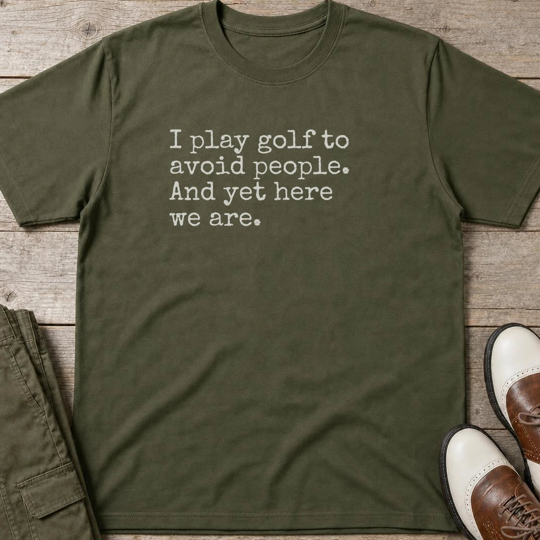 Avoid People T-Shirt in Military Green lying on a plain floor. T-shirt is a unisex cut and 100 per cent cotton.