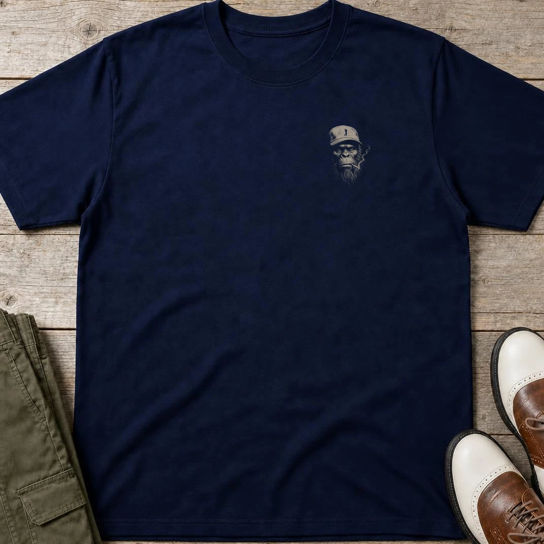 Big Foot Pocket T-Shirt in Navy lying on a plain floor. T-shirt is a unisex cut and 100 per cent cotton.
