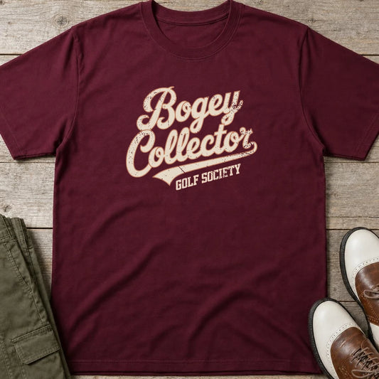 Bogey Collector T-Shirt in Maroon lying on a plain floor. T-shirt is a unisex cut and 100 per cent cotton.