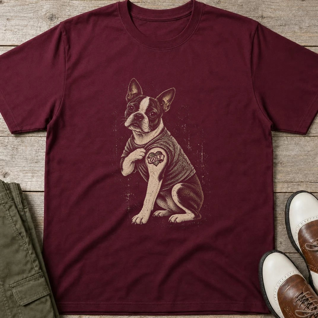 Boston Terrier Golf T-Shirt in Maroon lying on a plain floor. T-shirt is a unisex cut and 100 per cent cotton.