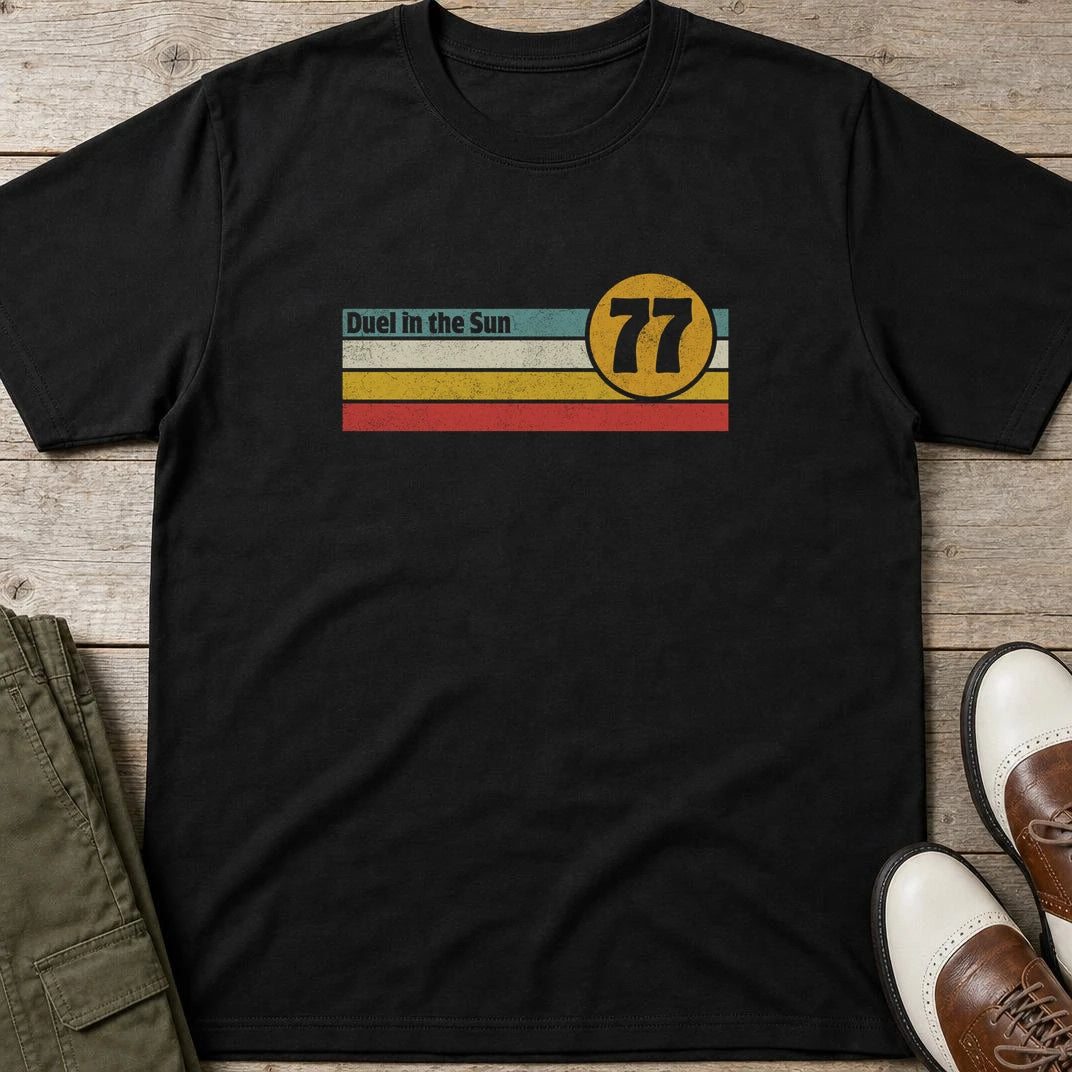 Duel Sun T-Shirt in Black lying on a plain floor. T-shirt is a unisex cut and 100 per cent cotton.
