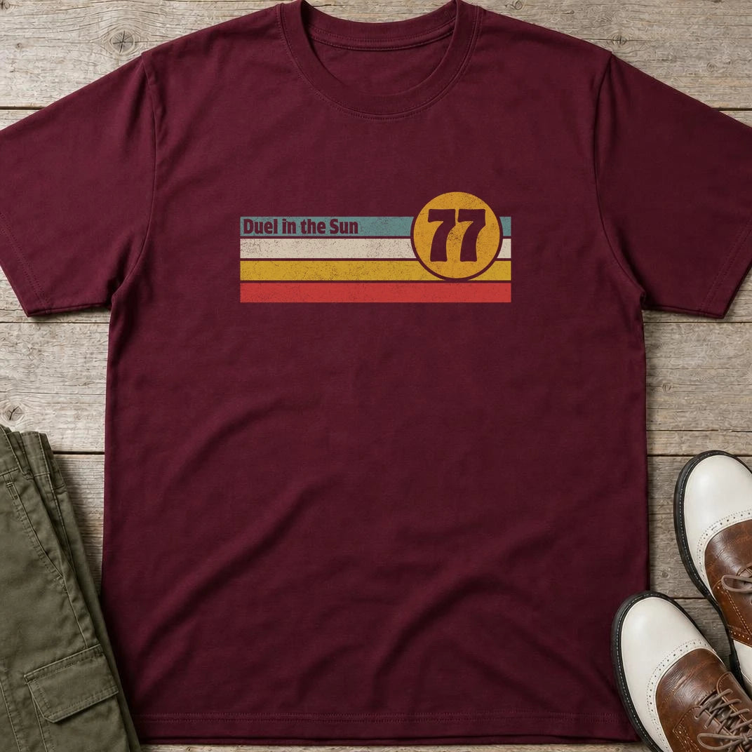 Duel Sun T-Shirt in Maroon lying on a plain floor. T-shirt is a unisex cut and 100 per cent cotton.