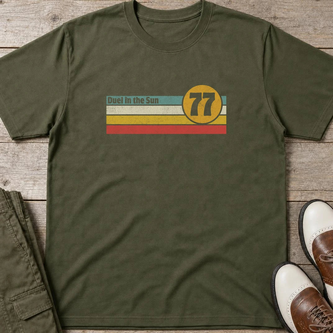 Duel Sun T-Shirt in Military Green lying on a plain floor. T-shirt is a unisex cut and 100 per cent cotton.