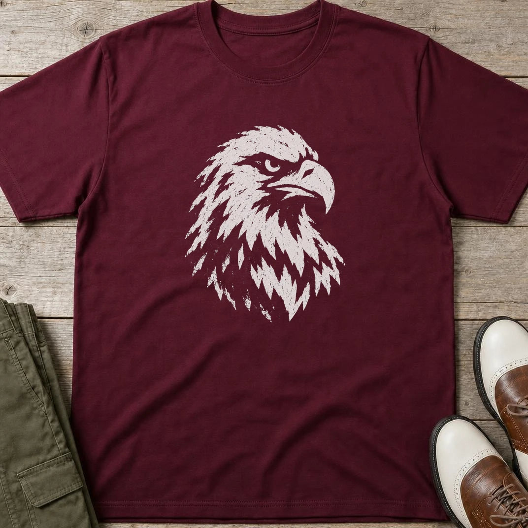 Eagle Graphic T-Shirt in Maroon lying on a plain floor. T-shirt is a unisex cut and 100 per cent cotton.