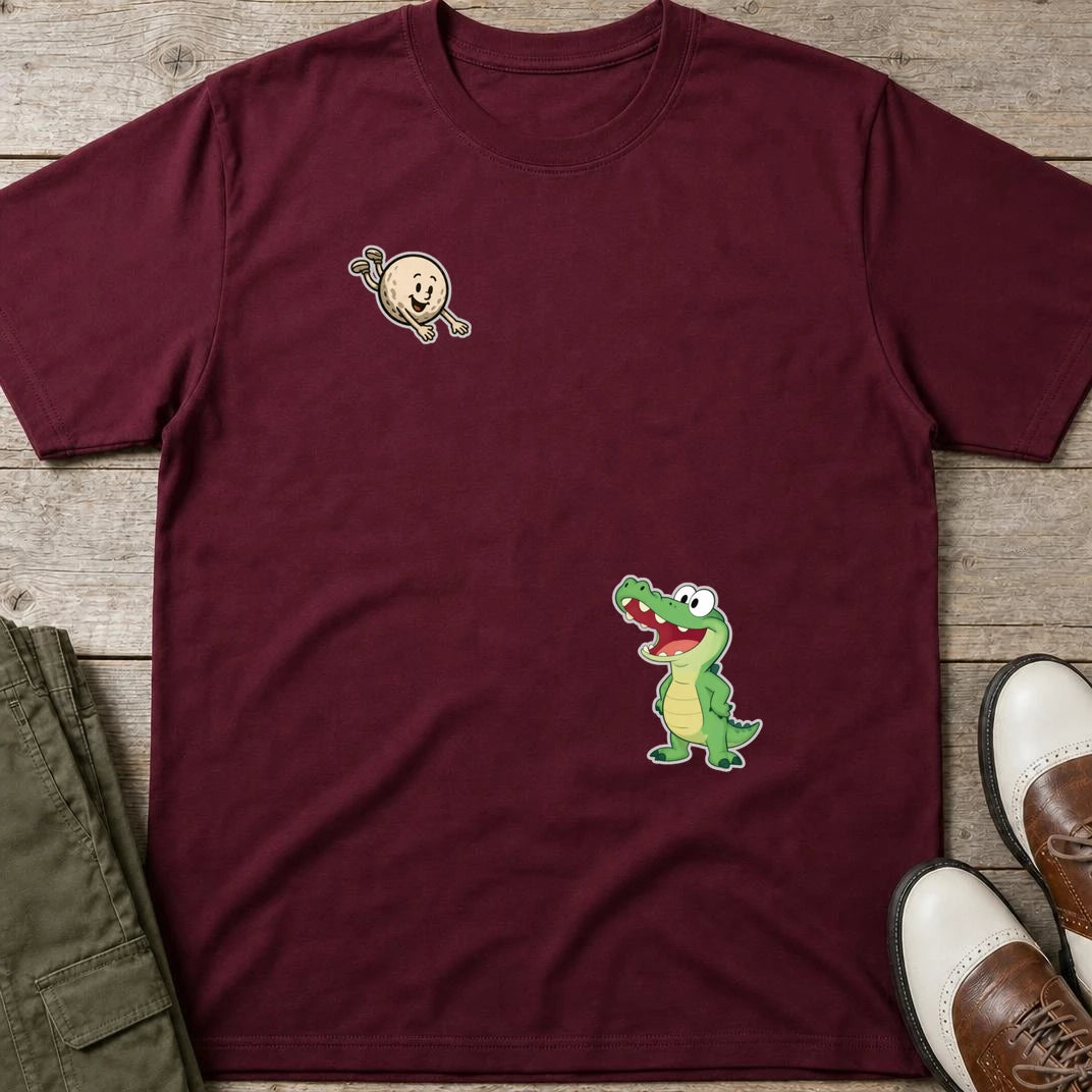 Flying Golf Croc T-Shirt in Maroon lying on a plain floor. T-shirt is a unisex cut and 100 per cent cotton.